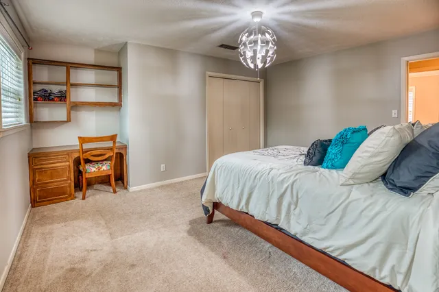 a bedroom with a bed and a chandelier