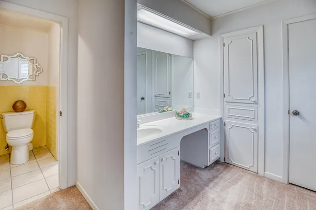 a bathroom with a sink mirror vanity and toilet