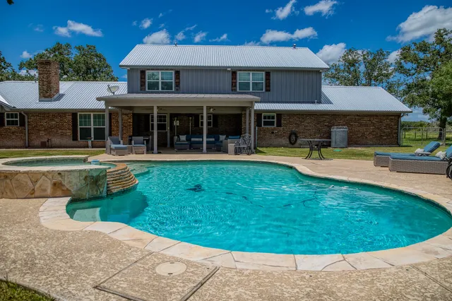 a view of a house with swimming pool and sitting area