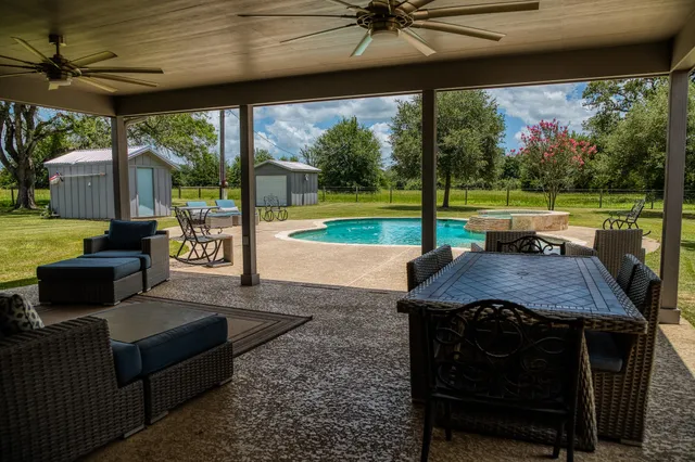 a view of a patio with a table chairs and a backyard