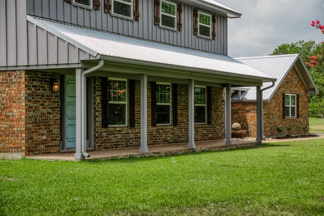 a view of a house with a large window and a yard