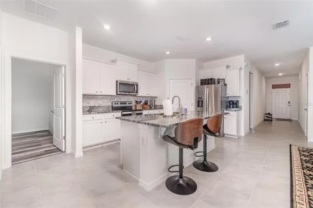 a living room with furniture kitchen view and a refrigerator