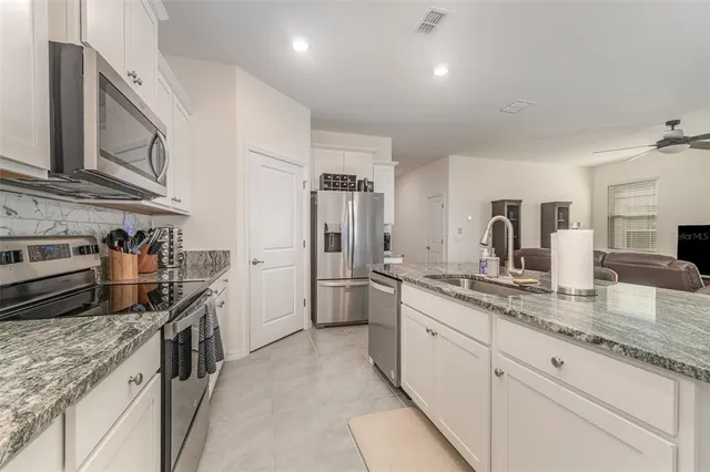 a bedroom with a bed ceiling fan and a window