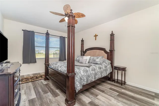 a bedroom with a bed and a flat tv screen on dresser