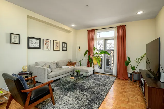 a living room with furniture a window and a flat screen tv