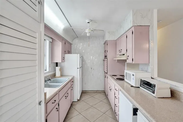 a kitchen with granite countertop a sink stove and refrigerator