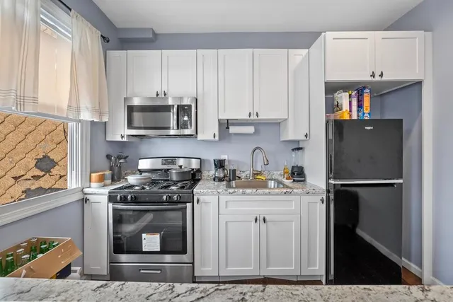 a kitchen with stainless steel appliances granite countertop a refrigerator sink and stove
