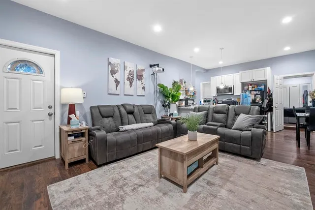 a living room with furniture and a wooden floor