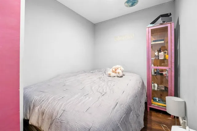 a bedroom with a bed and a wooden floor