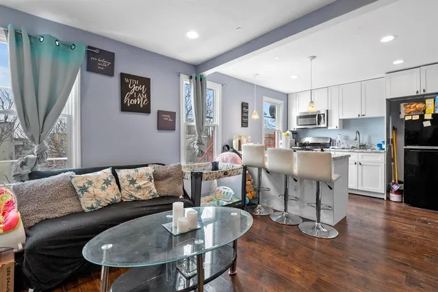 a living room with fireplace furniture and a dining table with kitchen view