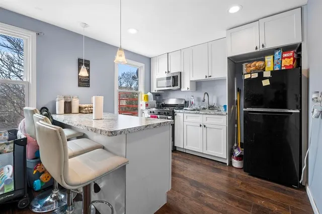 a kitchen with a sink refrigerator and cabinets