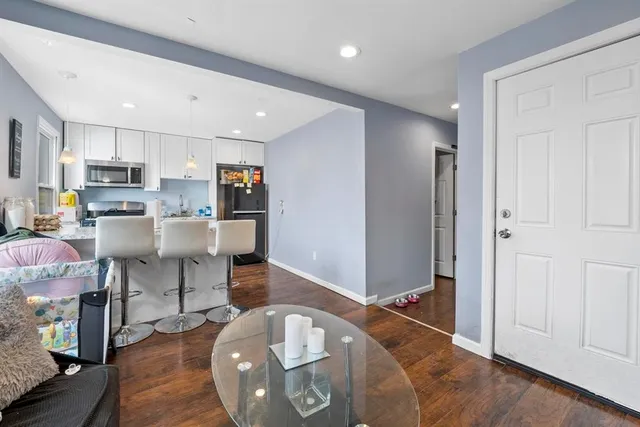 a living room with stainless steel appliances lots of wooden furniture