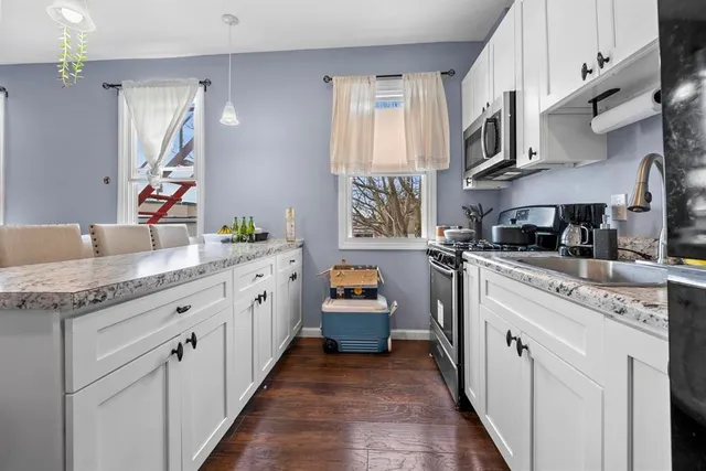 a kitchen with stainless steel appliances granite countertop a sink and dishwasher a stove top oven with wooden floor