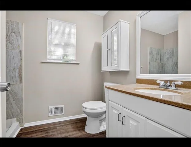 a bathroom with a sink a toilet and a mirror