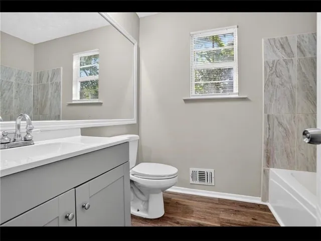 a bathroom with a sink toilet and window