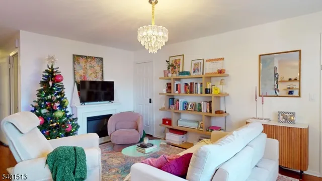a living room with furniture a bookshelf and a flat screen tv