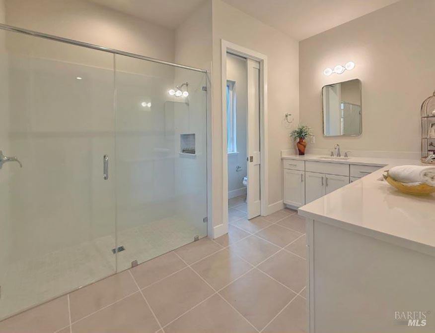 1901 Carlile Place Santa Rosa, CA 95403 - Photo 13 of 29 Here is the beautiful main level primary suite bathroom, offering double sink vanity with quartz counters, an oversized curb less stall shower. Look at this tile floor!