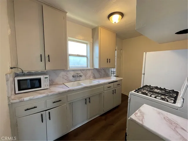 a kitchen with stainless steel appliances granite countertop a sink stove and cabinets