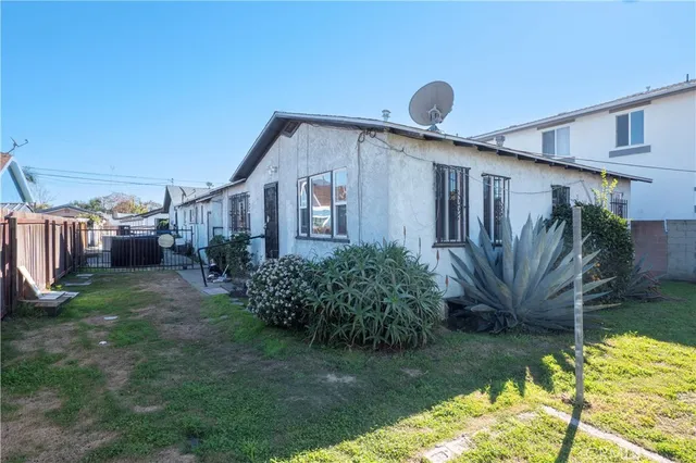 a backyard of a house with potted plants and wooden fence