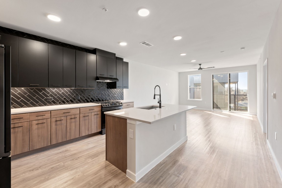 4510 Terry-O Lane, Unit 302 Austin, TX 78745 - Photo 1 of 25 a kitchen with granite countertop a sink and cabinets with wooden floor