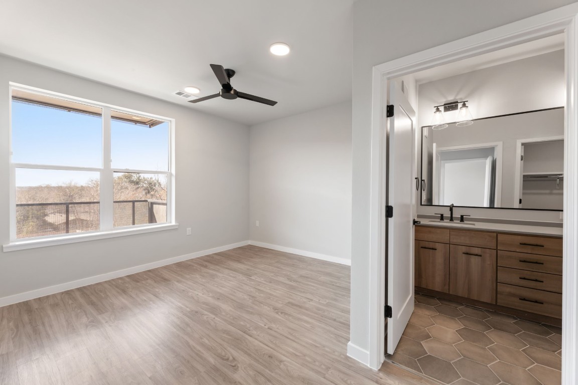 4510 Terry-O Lane, Unit 302 Austin, TX 78745 - Photo 6 of 25 a bathroom with a granite countertop sink a mirror and a window