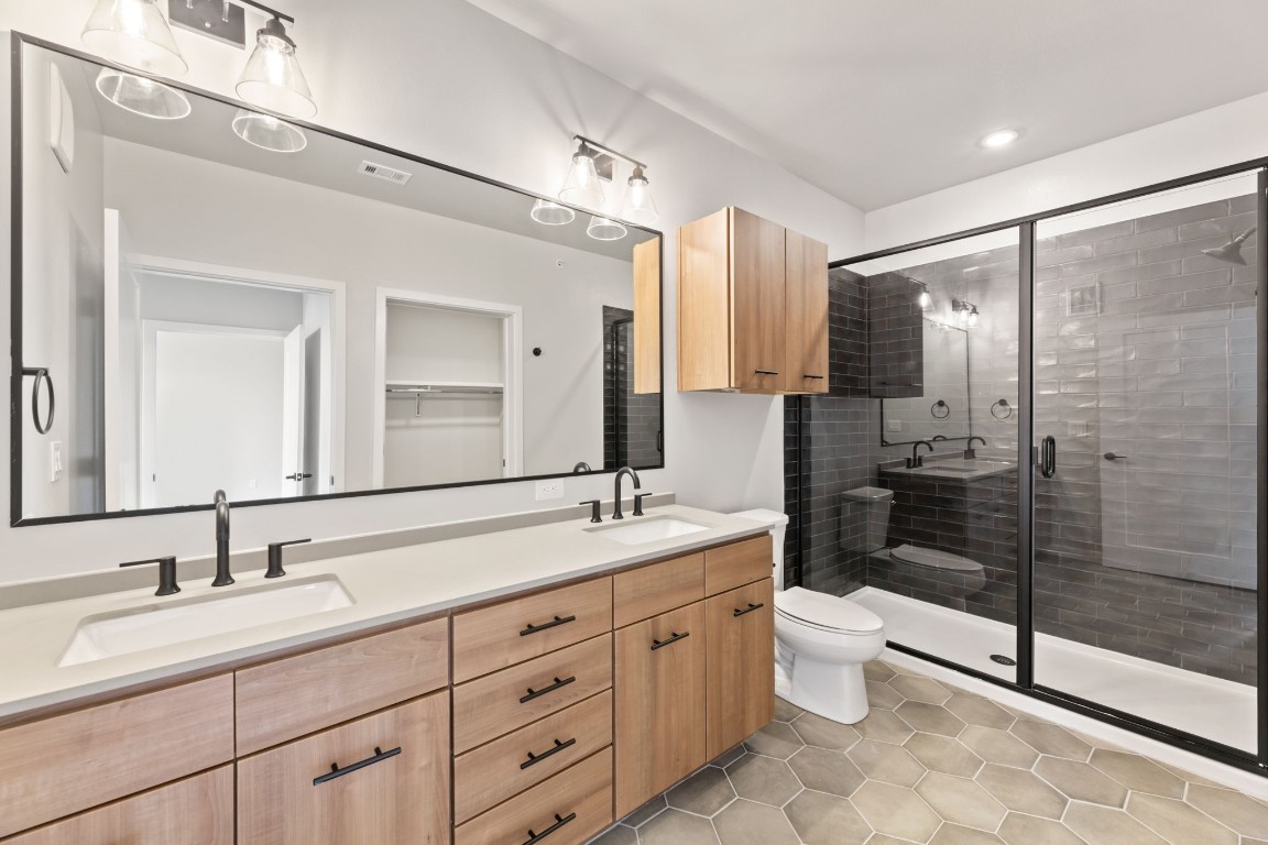 4510 Terry-O Lane, Unit 302 Austin, TX 78745 - Photo 7 of 25 a spacious bathroom with double sink a toilet a mirror and shower