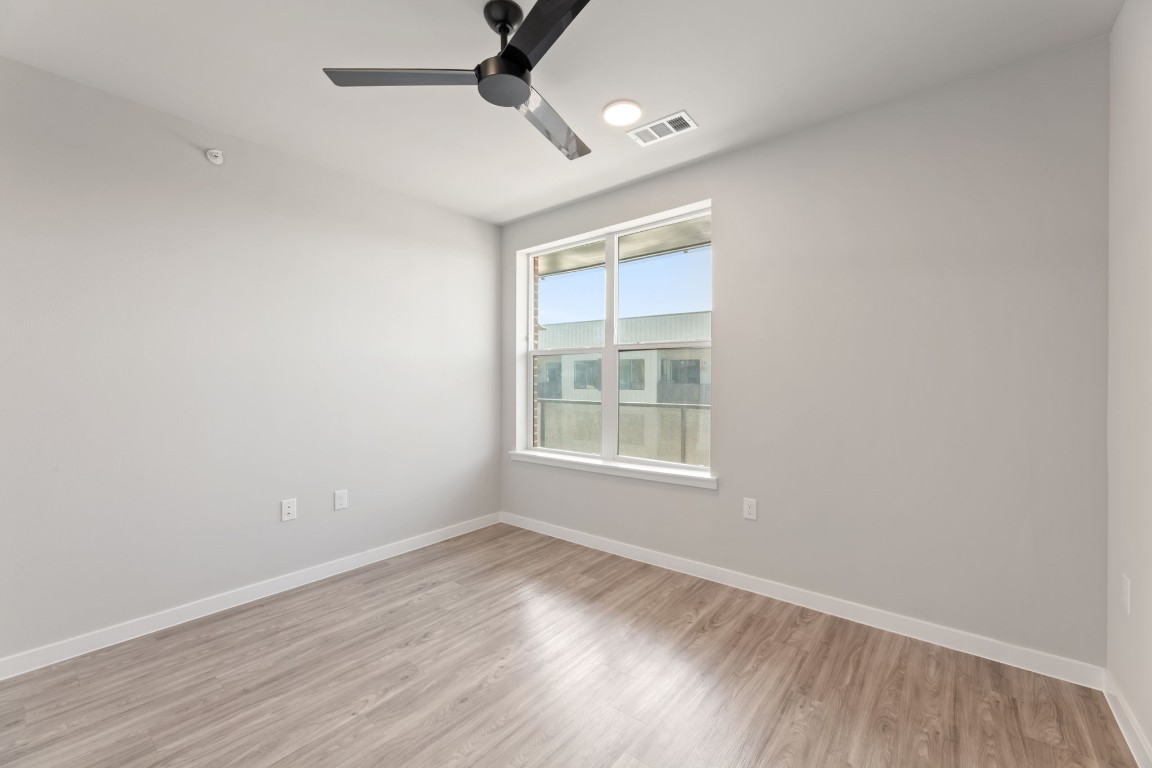 4510 Terry-O Lane, Unit 302 Austin, TX 78745 - Photo 9 of 25 an empty room with wooden floor fan and windows