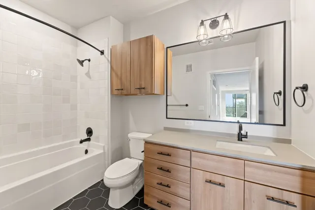 a bathroom with a granite countertop toilet a sink and a bathtub