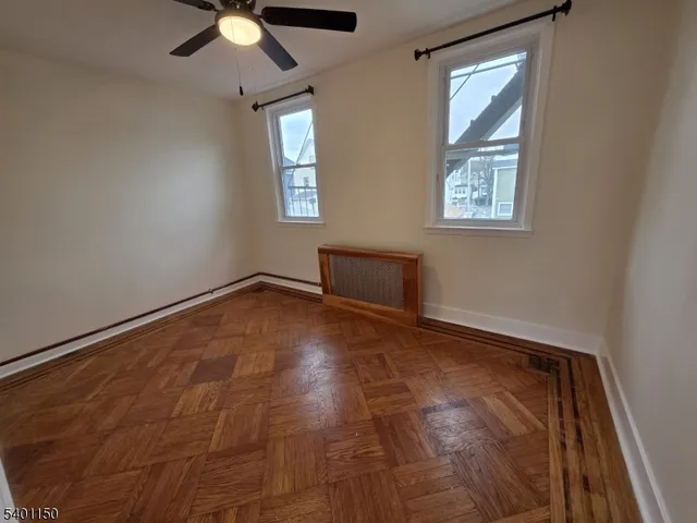 an empty room with windows and fan