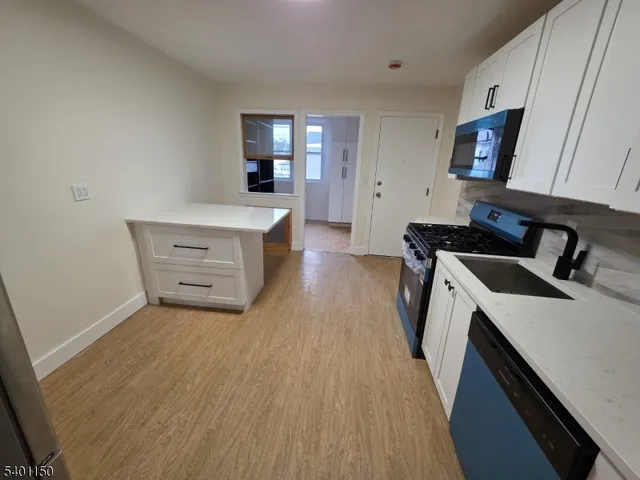 a kitchen with a sink a stove and cabinets