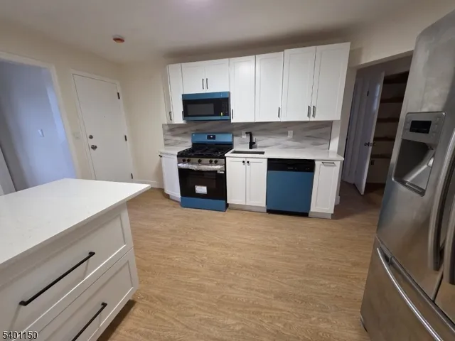a kitchen with stainless steel appliances a stove microwave and a refrigerator