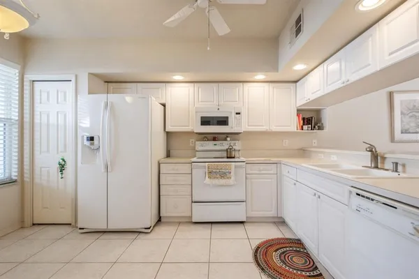 a kitchen with white cabinets and white appliances