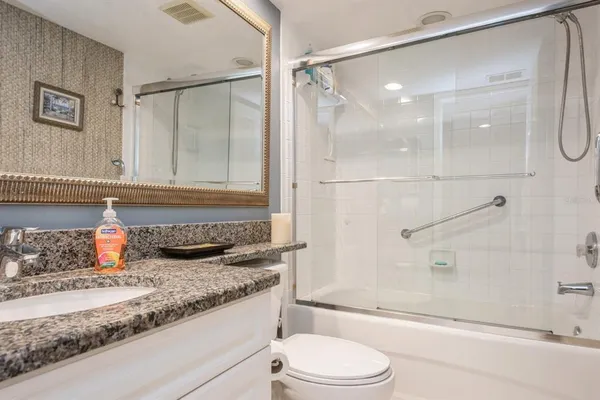 a bathroom with a granite countertop sink toilet and shower