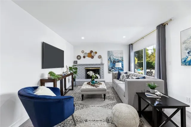 a living room with furniture a fireplace and a flat screen tv