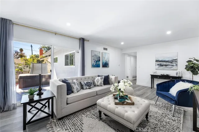 a living room with furniture and a wooden floor
