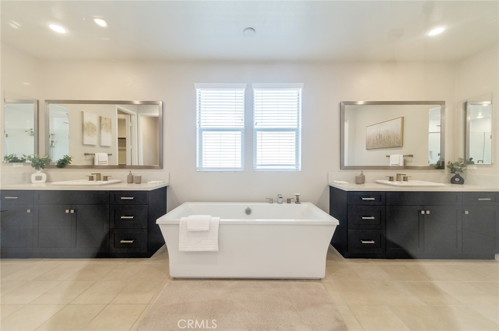 113 Measure Irvine, CA 92618 - Photo 26 of 39 a spacious bathroom with a double vanity sink large mirror bathtub and window