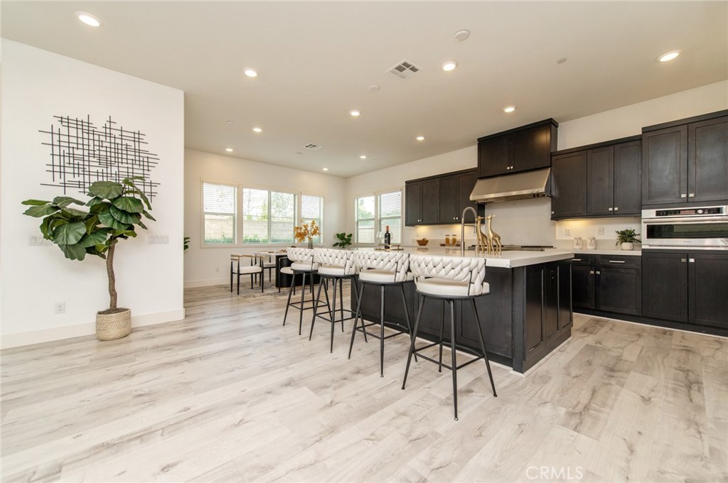 113 Measure Irvine, CA 92618 - Photo 8 of 39 a kitchen with stainless steel appliances kitchen island granite countertop a stove a sink a dining table and chairs