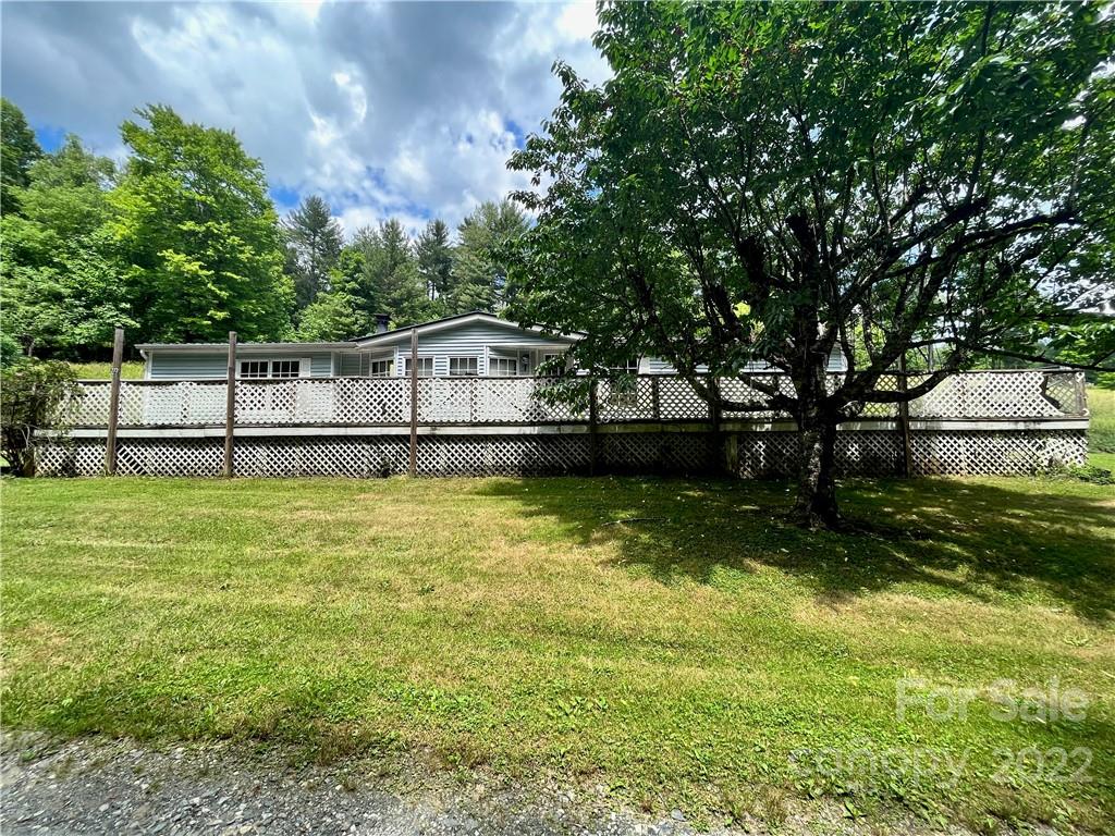 a view of a house with a big yard and sitting area