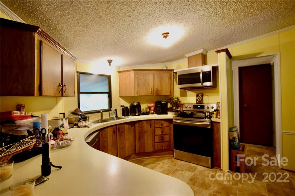 272 Lloyd Drive Mars Hill, NC 28754 - Photo 7 of 21 a kitchen with kitchen island granite countertop a sink stove and refrigerator