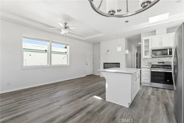 a kitchen with granite countertop a stove cabinets and wooden floor