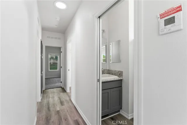 a view of hallway with sink and wooden floor