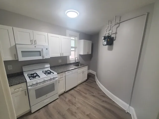 a kitchen with white cabinets and white appliances