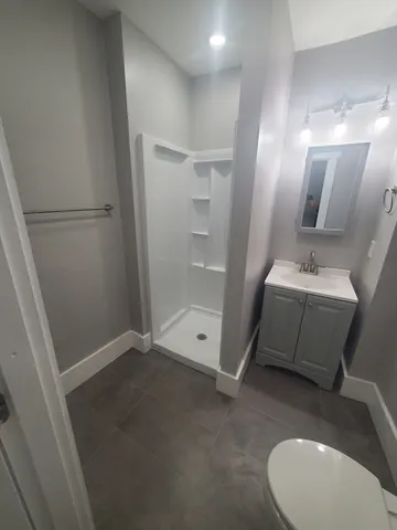 a bathroom with a sink a toilet and mirror