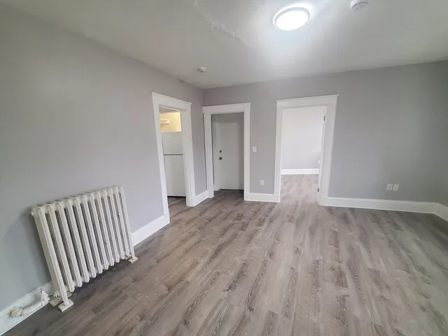 a view of a room with wooden floor and window