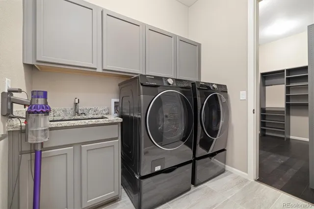 a utility room with sink dryer and washer