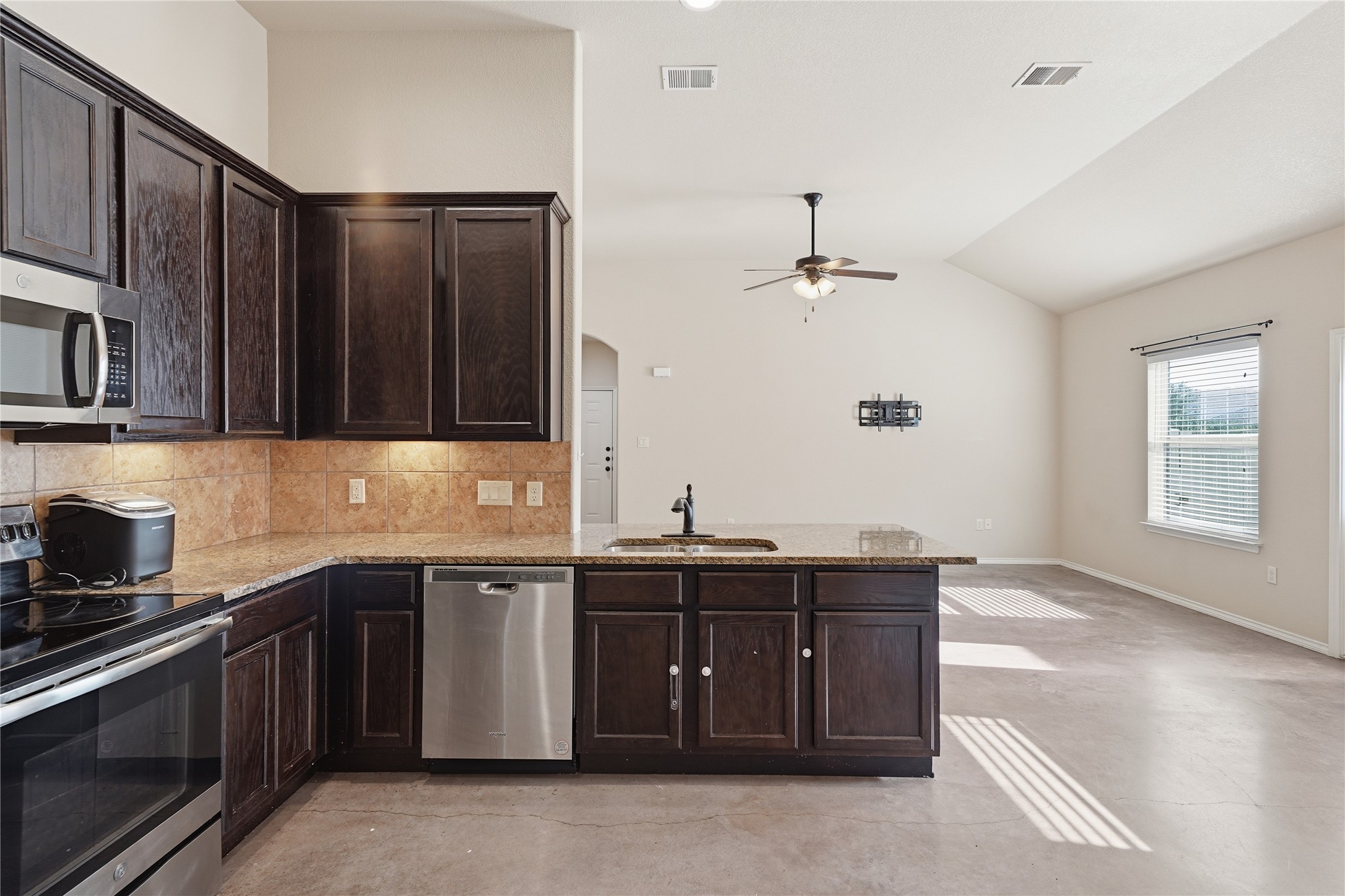 533 Jack Rabbit Lane, Unit A Buda, TX 78610 - Photo 16 of 34 A well-appointed kitchen island with sleek appliances opens to a generously sized living area.
