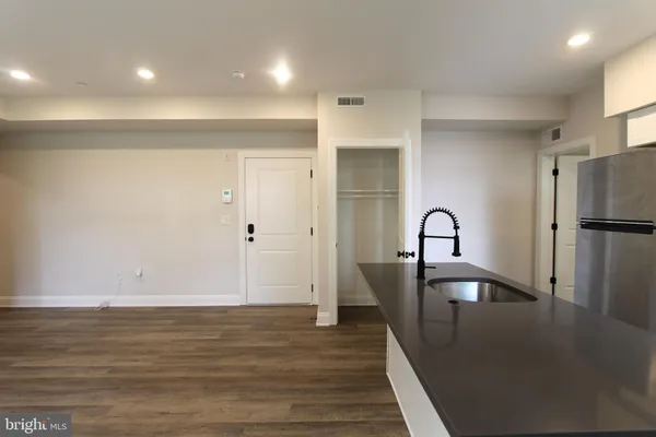 a view of a kitchen with a sink and refrigerator