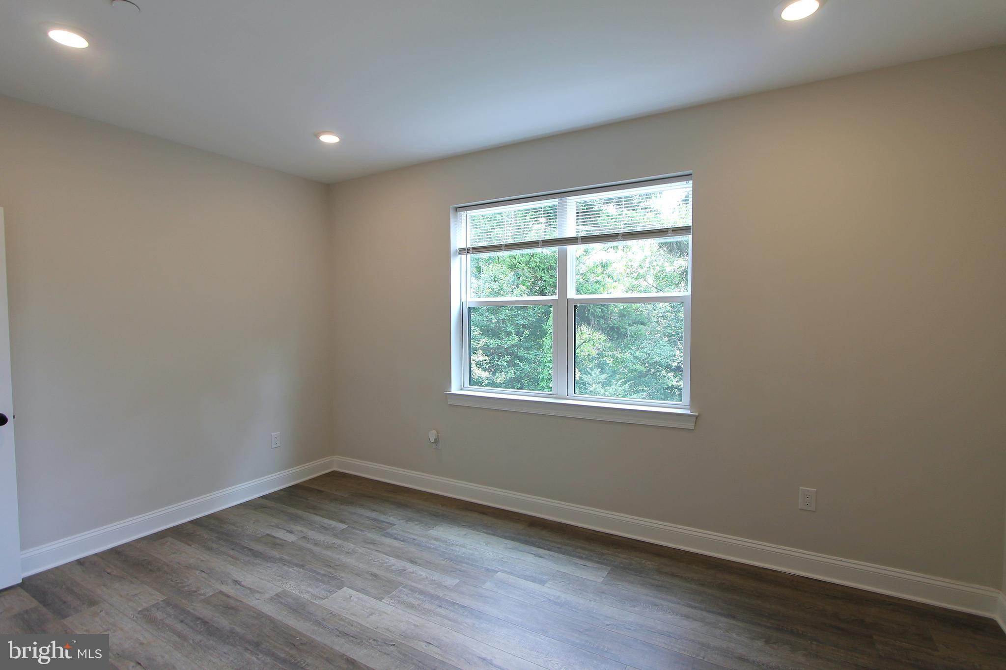 492 Roxborough Avenue, Unit 403 Philadelphia, PA 19128 - Photo 19 of 28 an empty room with wooden floor and windows