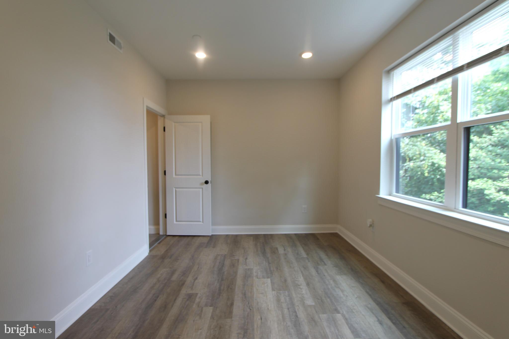 492 Roxborough Avenue, Unit 403 Philadelphia, PA 19128 - Photo 20 of 28 wooden floor in an empty room with a window