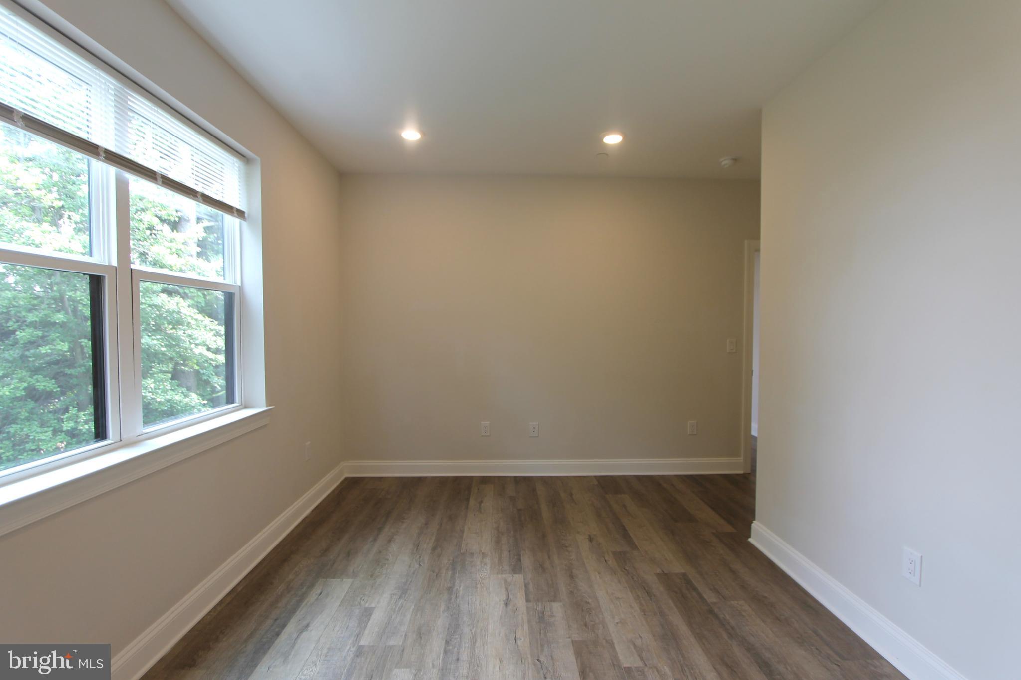 492 Roxborough Avenue, Unit 403 Philadelphia, PA 19128 - Photo 23 of 28 an empty room with wooden floor and windows